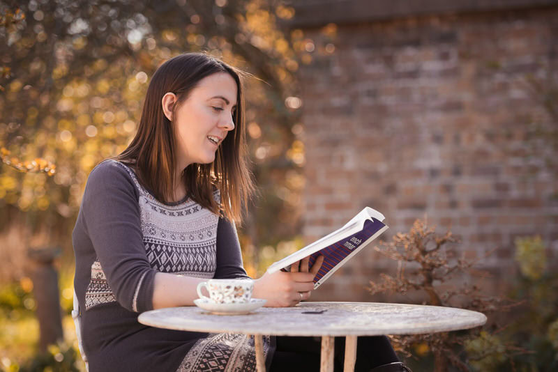Branding Photographer Edinburgh - woman sitting at table in cafe reading magazine