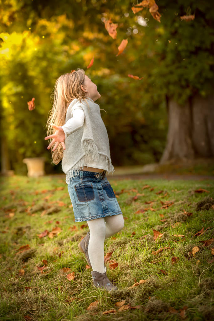 Family photographer Edinburgh - little girl throwing autumn leaves in the air