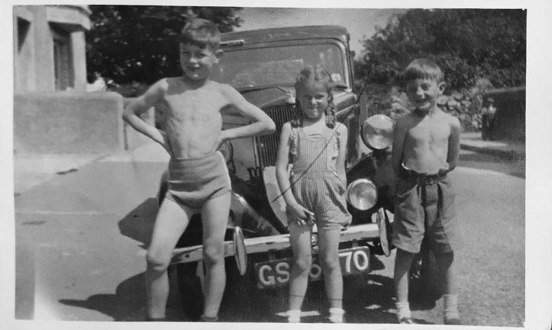 Family photographer Edinburgh - old black and white photo from 1950s of three children standing against vintage car