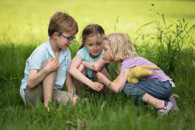 Family photoshoot Edinburgh - three children sitting in grass with dandelion