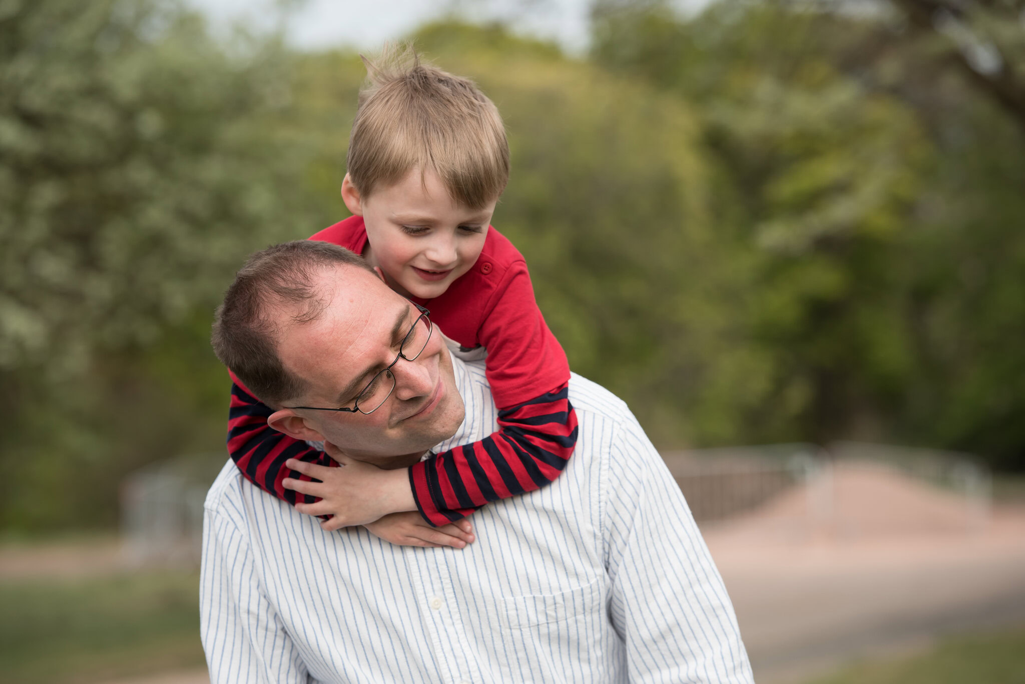 Family photography in Edinburgh - little boy sitting on his father's back with arms round his neck at Calton Hill