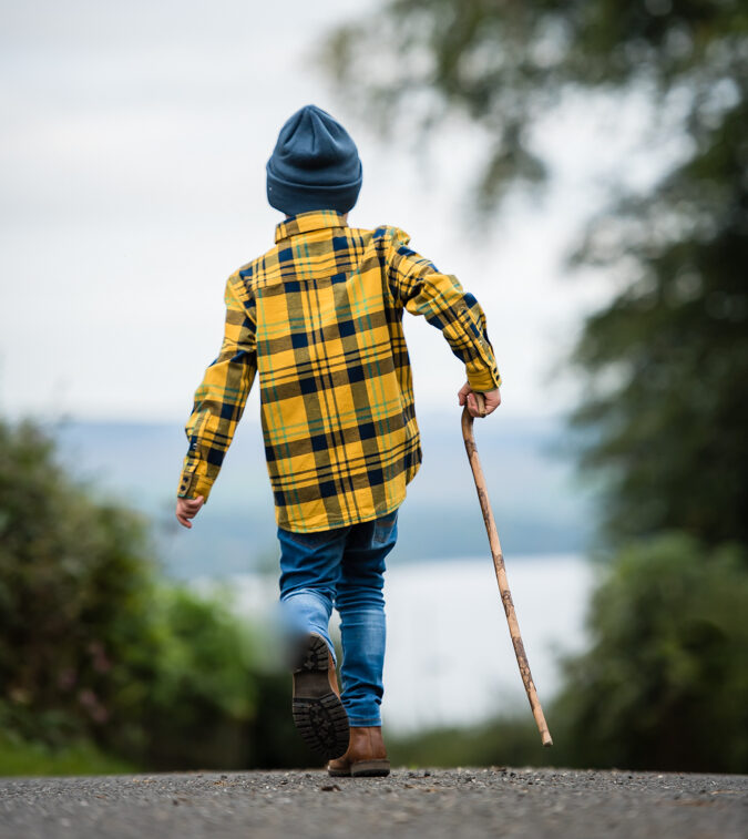 Edinburgh branding and headshot photography - small boy with yellow tartan shirt and shepherds crook walking away from camera