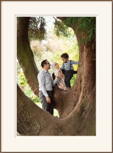 Framed portrait photograph of parents with 3 year old boy standing in a tree 