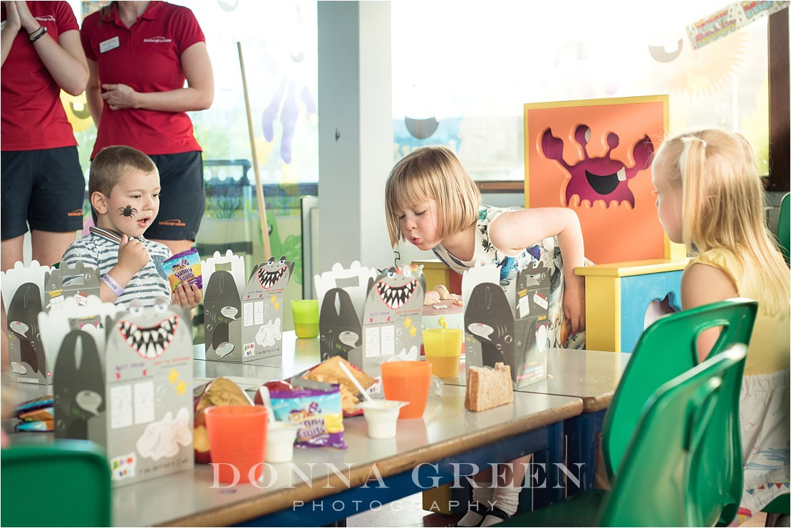 Family photography in Edinburgh of little girl blowing out birthday cake candles