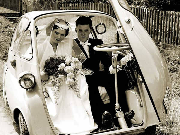 bride and groom in 1960s bubble car, black and white