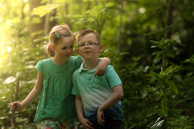 little girl and boy in the woods