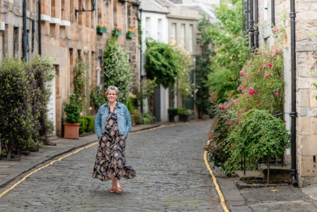Scotland Personal branding photoshoot in Edinburgh - woman in maxi dress and denim jacket walking down cobbled street, Circus Lane, Eidnburgh
