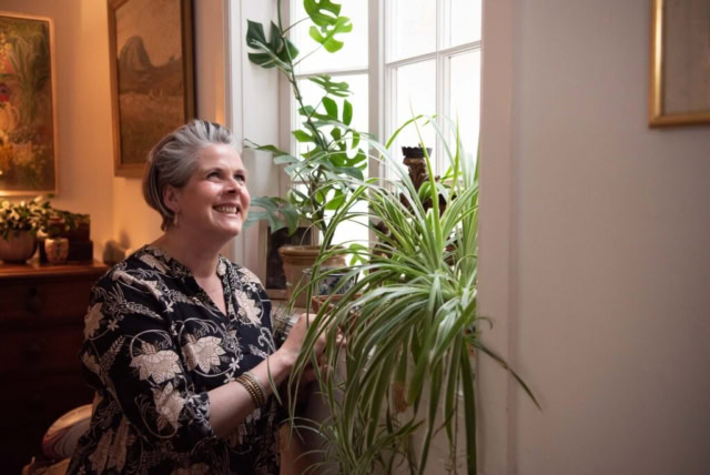 Brand photrography shoot in Scotland - woman tending to spider plant indoors