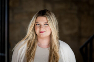 Headshot of textile designer from Galashiels in the Scottish Borders, taken in Edinburgh, Scotland, of young woman with long blonde hair and white top