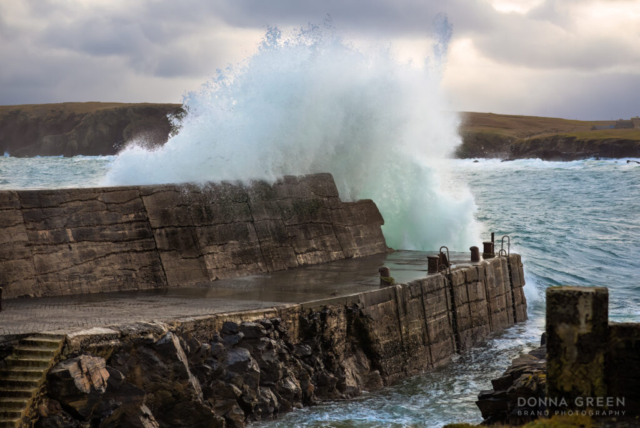 Port of Ness, Isle of Lewis, Outer Hebrides - the harbour wall with wave crashing over it