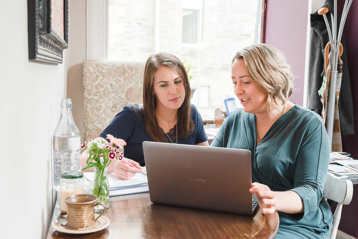 Two women working in cafe on laptop