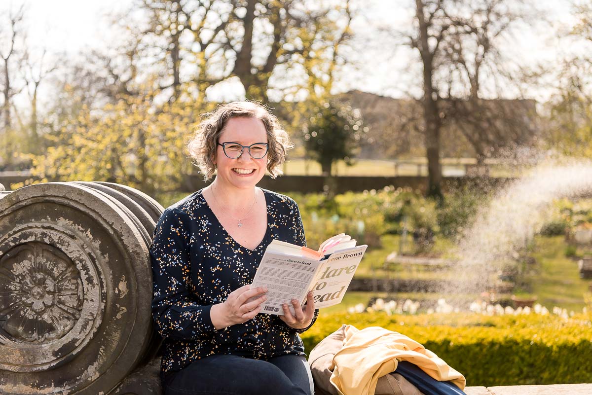 Woman reading Brene Brown book in garden