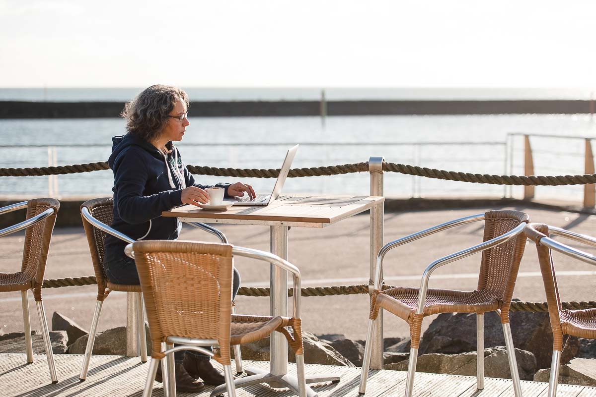 Woman sitting outdoors with laptop