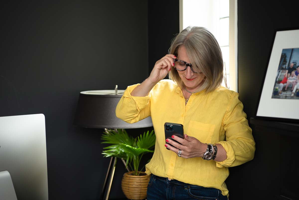 Woman in yellow shirt looking at phone