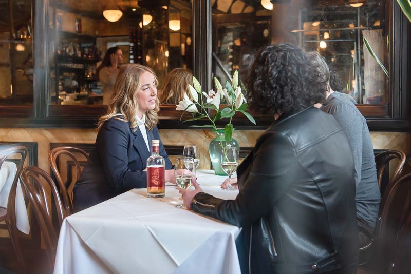 Brand photo shoot in Edinburgh in cafe with two women chatting over a glass of wine