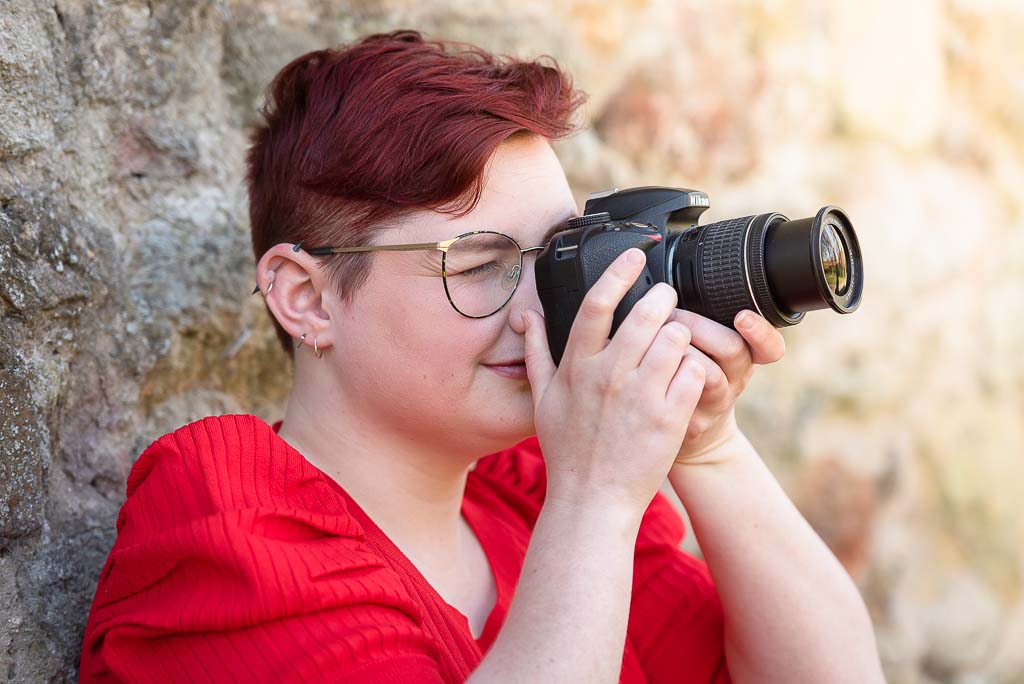 Choose the right editing stylel - Headshot photographer Edinburgh - image of woman in red top holding camera to her eye