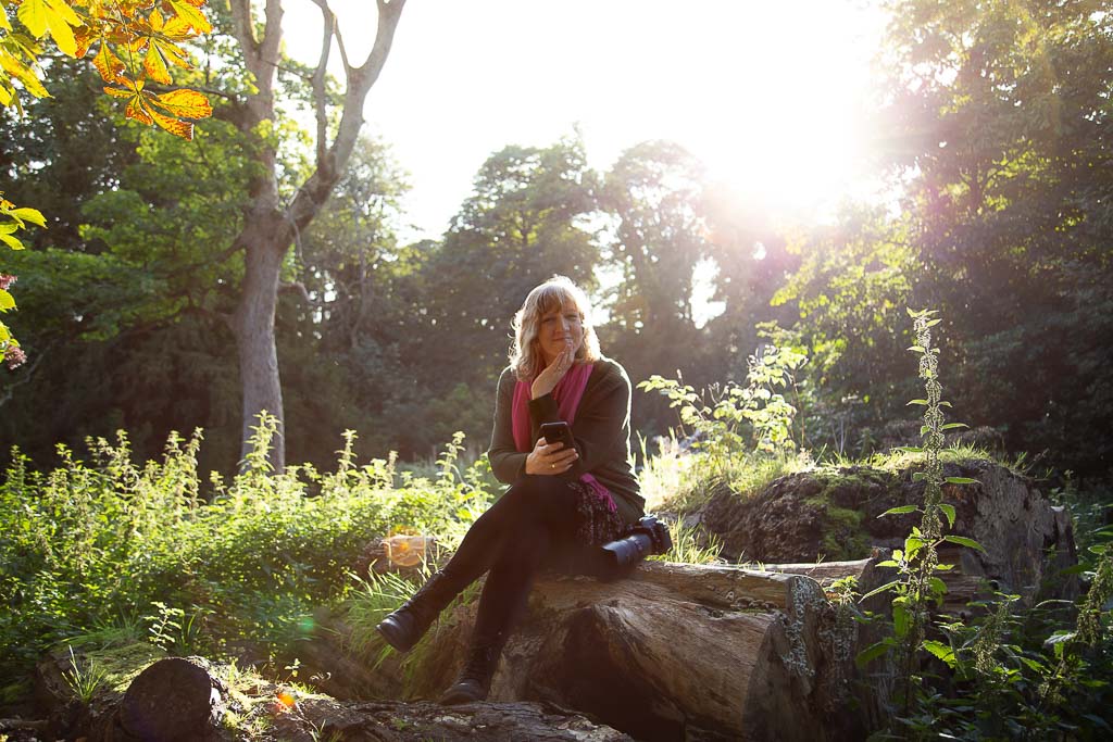 personal branding photo shoot in Edinburgh for headshot photographer who is sitting on a felled tree in the woods