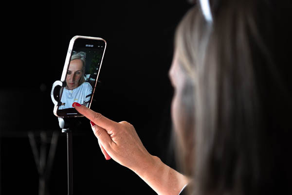 How to take business photos for the technology industry, demonstrated by close up of a woman filming herself on a mobile phone in Glasgow, Scotland