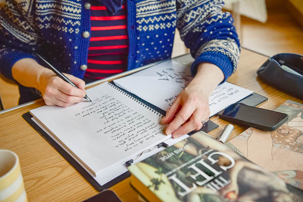 How to take business photos in the creative industry illustrated by poet in Edinburgh, Scotland, handwriting a  poem with pen and ink in a large notebook