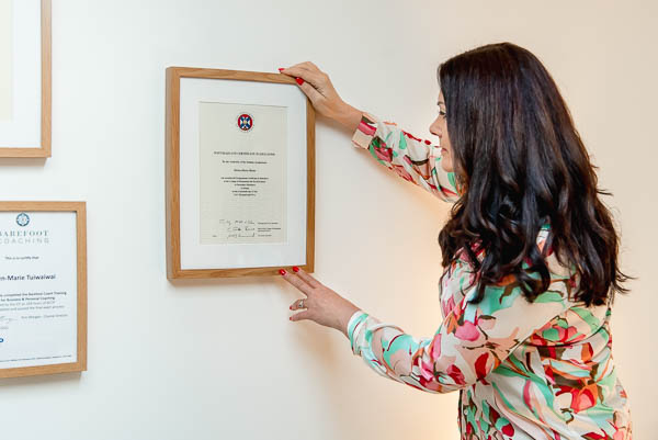 How to take business photos - brand photography in Edinburgh, Scotland, showing business coach hanging professional certificate on the wall
