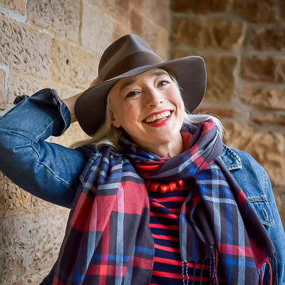 Brand photographer Edinburgh Scotland - headshot of creative artist and writer, woman with white hair and fedora hat and red and blue tartan scarf