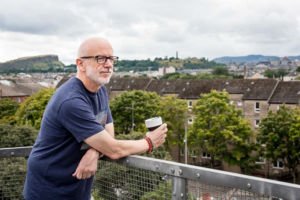 Brand photoshoot in Edinburgh, Scotland, with a small business owner consultant standing by railings overlooking the city.