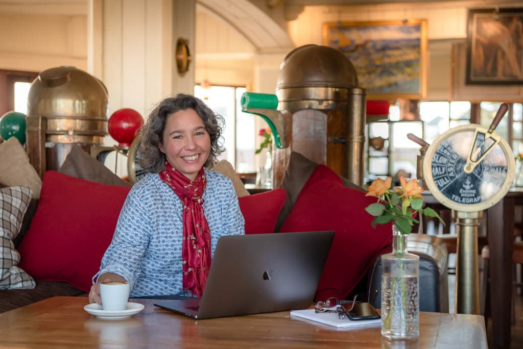 Brand photography in Scotland showing a small business owner working on a laptop in  a cafe in Arbroath, Angus