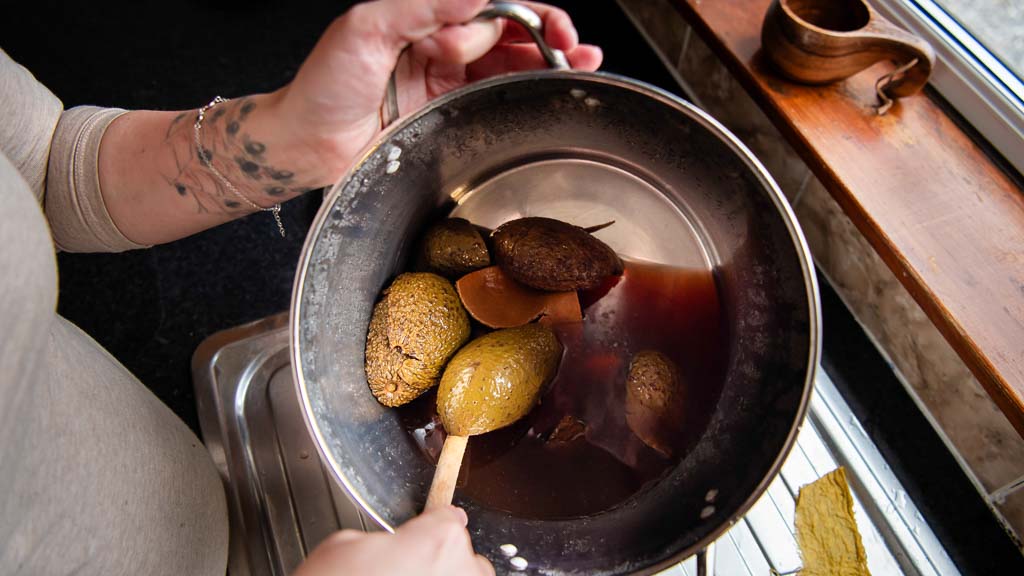 Heritage craftswoman boiling avocado skins to make natural dye by hand in her kitchen on the Moray coast, an image designed to show the value of your work, photographed by a brand photographer in Scotland.