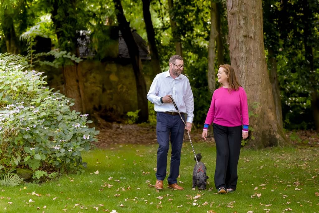 Personal brand photography in Glasgow showing consultant Yvonne Anderson walking with her husband and dog